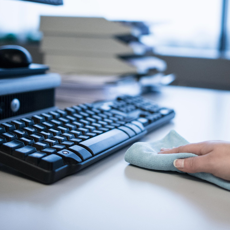 Un clavier est nettoyé avec une lingette en microfibre